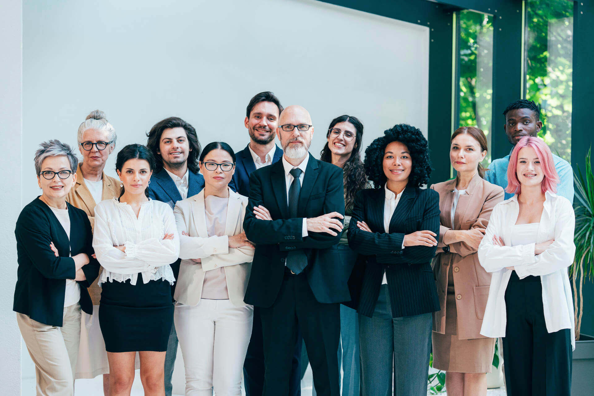 Group of business people standing with arms folded in a bright office, the staff of a UAE corporate whose accounts and devices need protecting